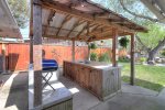 Outdoor kitchen space with sink and charcoal grill